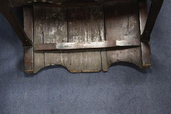 An 18th century boarded oak framed armchair,